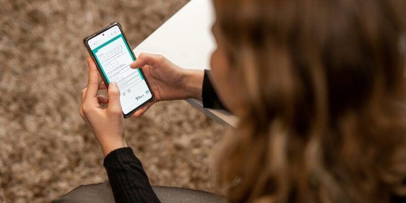 a woman sitting on the ground looking at her cell phone